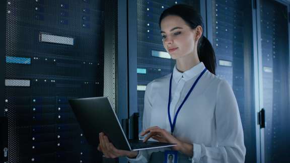 Intel expert using a laptop inside a high tech server room data center